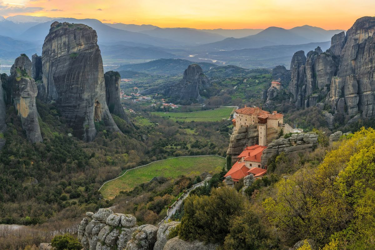 Towering rock pillars with a monastery perched above a verdant valley at Meteora.